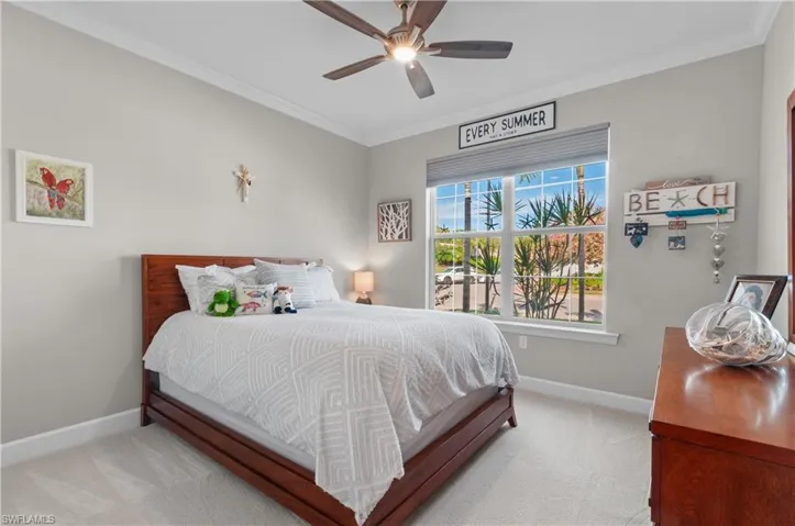 Bedroom featuring ceiling fan, light colored carpet, and crown molding