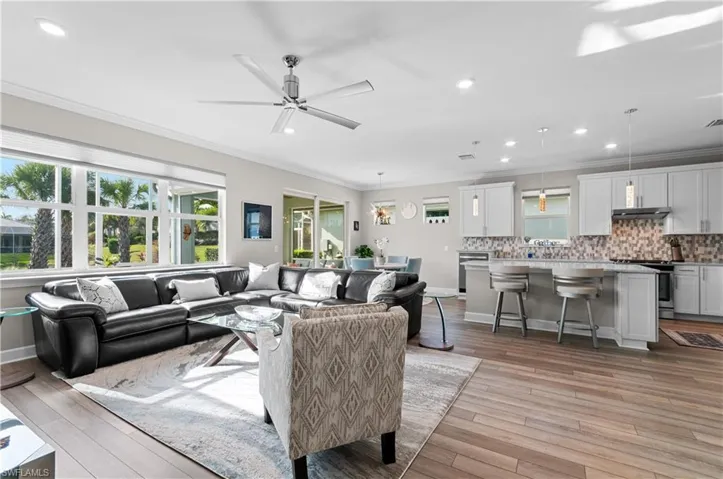 Living room with light hardwood / wood-style flooring, ceiling fan, and crown molding