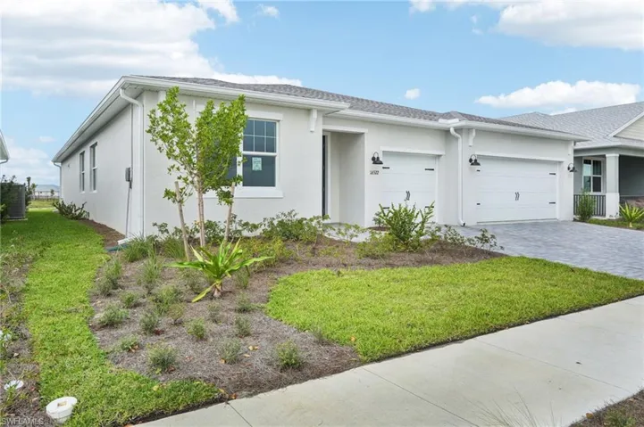 Ranch-style home with a front lawn and a garage
