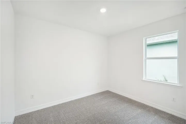 Carpeted spare room featuring a healthy amount of sunlight