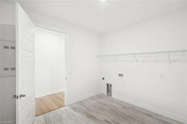 Clothes washing area featuring light hardwood / wood-style floors, electric dryer hookup, and washer hookup