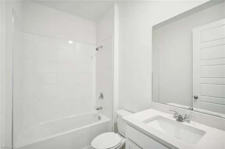 Full bathroom featuring toilet, vanity, and tiled shower / bath