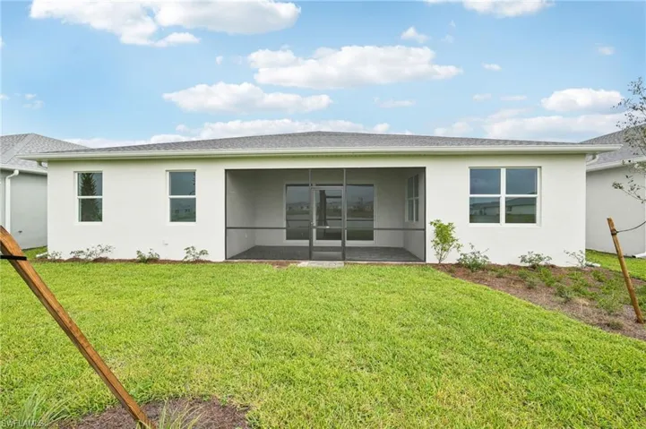 Back of house with a lawn and a patio