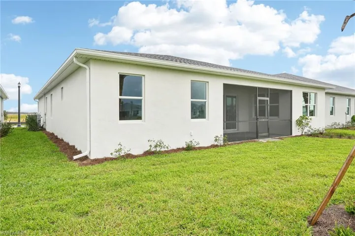 Rear view of property featuring a lawn and a sunroom
