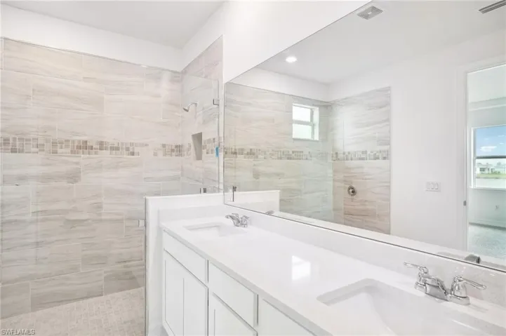 Bathroom with vanity and a tile shower