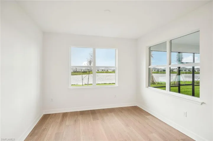 Empty room with a water view and light hardwood / wood-style flooring