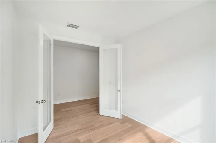 Unfurnished bedroom featuring light hardwood / wood-style floors and french doors