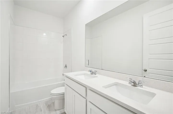 Full bathroom with vanity, toilet, and tiled shower / bath combo