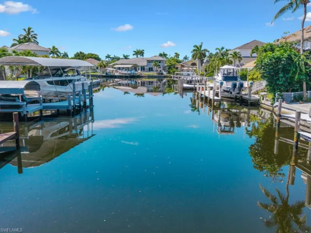 Dock area with boat lift, a water view, and a residential view