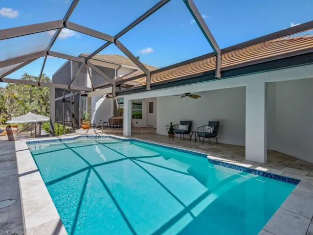 Outdoor pool with a ceiling fan, a patio area, and glass enclosure