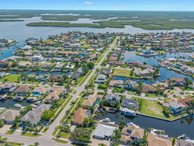 Aerial view of property and surrounding area featuring a large body of water and nearby suburban area
