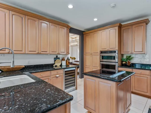 Kitchen with wine cooler, double oven, light tile patterned floors, decorative backsplash, and recessed lighting