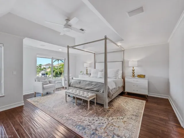 Bedroom featuring ornamental molding, dark wood finished floors, and ceiling fan
