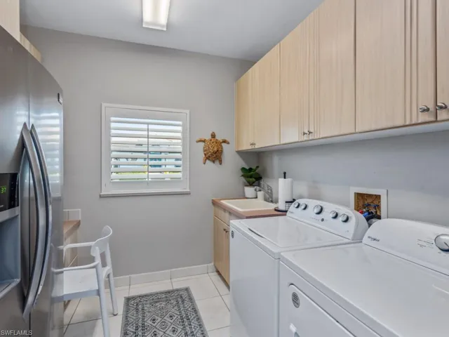 Washroom featuring washer and dryer and light tile patterned floors