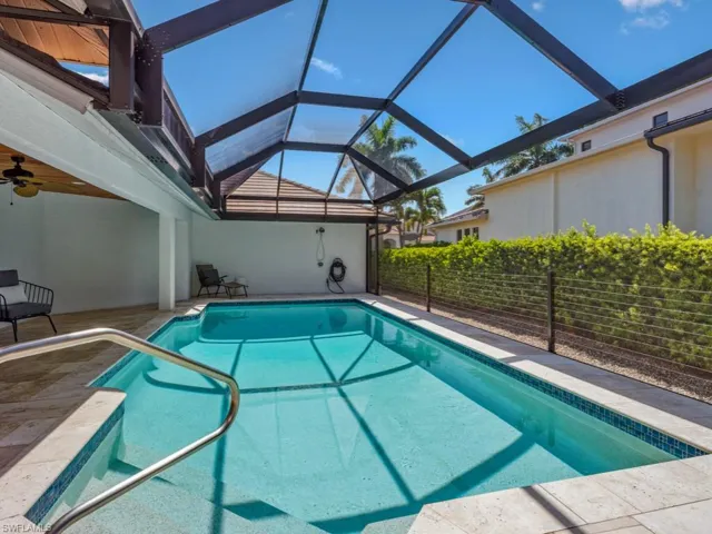 View of swimming pool featuring ceiling fan, a lanai, and a patio area