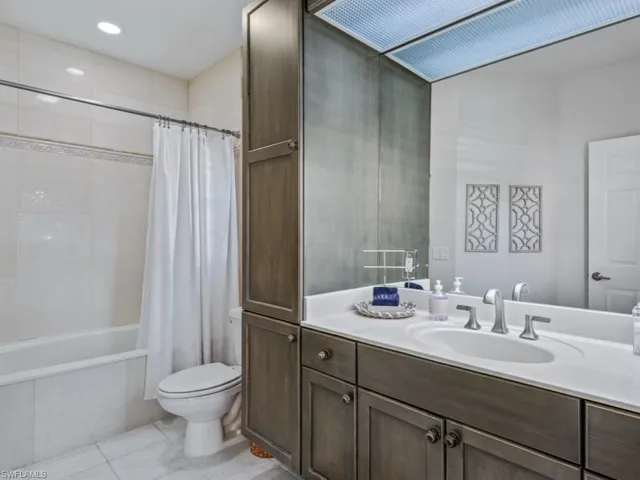 Bathroom with vanity, shower / tub combo, and tile patterned flooring