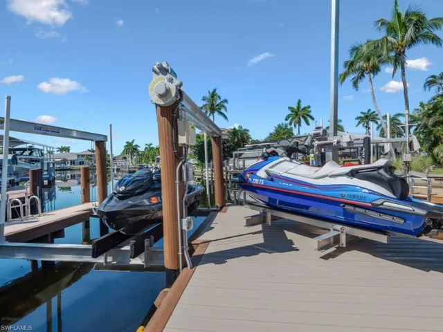 Dock area featuring boat lift and a water view