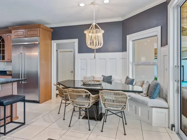 Dining area featuring a chandelier, ornamental molding, breakfast area, light tile patterned floors, and recessed lighting