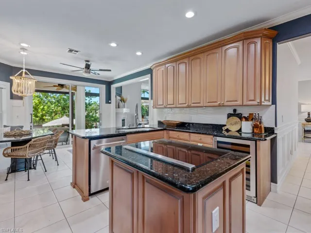 Kitchen featuring dishwasher, wine cooler, black electric stovetop, crown molding, and light tile patterned flooring