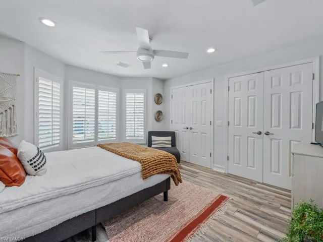 Bedroom featuring two closets, light wood-style floors, recessed lighting, and a ceiling fan