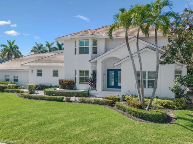 Front view of property with a yard, French doors, and a tile roof