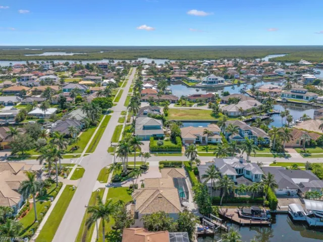 Aerial view of property and surrounding area with nearby suburban area and a nearby body of water