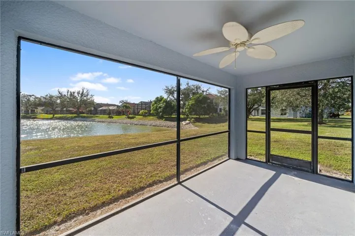 Unfurnished sunroom featuring a water view and a ceiling fan