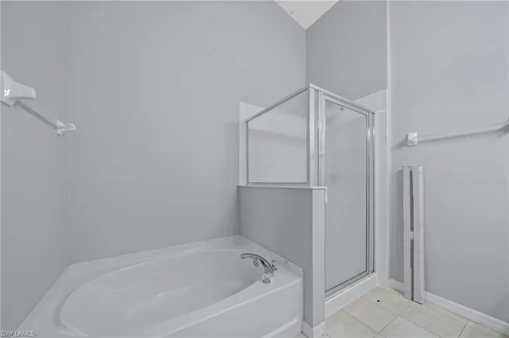 Bathroom featuring a bath, a shower stall, and light tile patterned floors