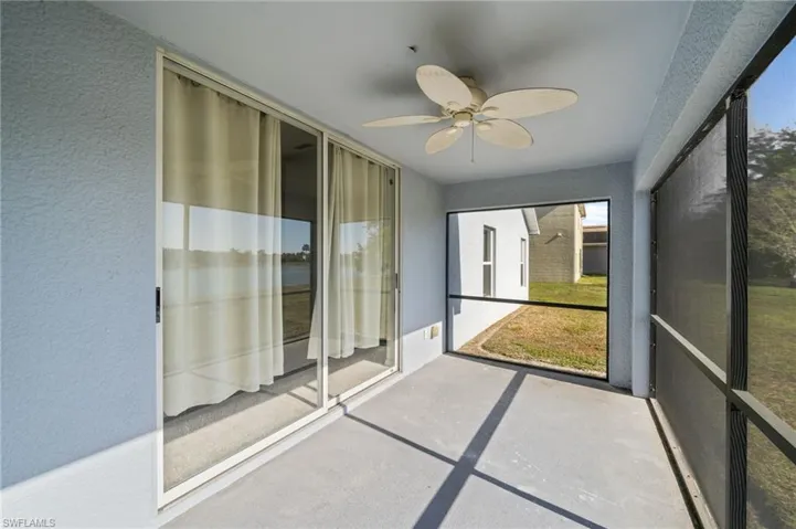 Unfurnished sunroom featuring ceiling fan, a water view, and healthy amount of natural light