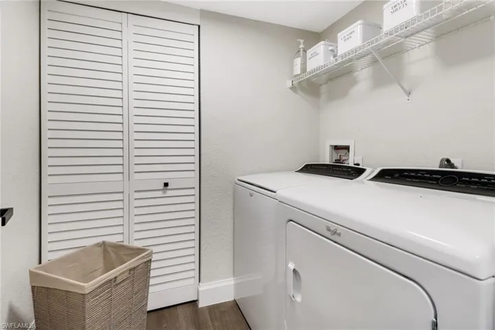 Laundry area featuring washer and clothes dryer and dark wood-type flooring