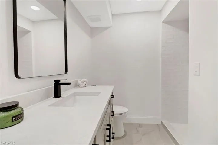 Bathroom featuring vanity, toilet, and walk in shower