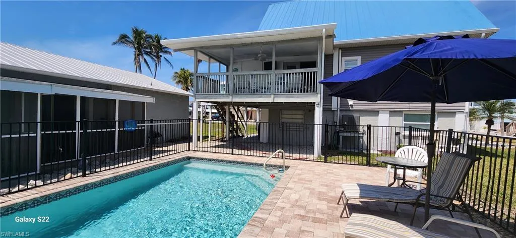 View of swimming pool with a fenced in pool, a sunroom, a patio, and fence