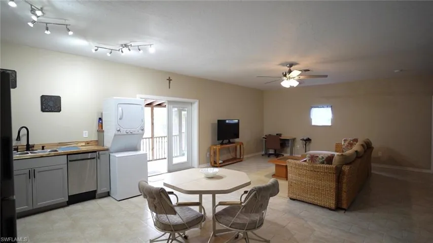 Dining room featuring sink, ceiling fan, and stacked washer / dryer