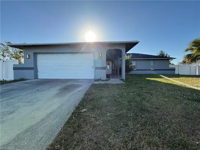 Ranch-style home with a garage and a front lawn