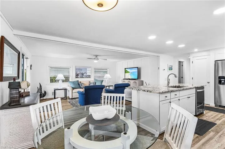 Dining area featuring light wood finished floors, plenty of natural light, a ceiling fan, and recessed lighting