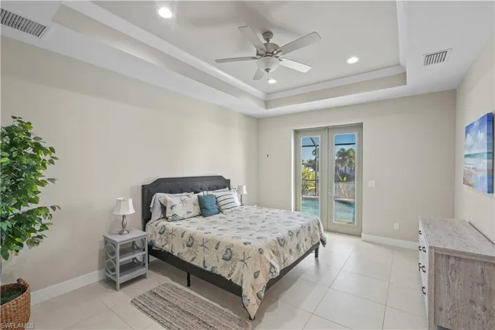 Bedroom with access to outside, recessed lighting, a ceiling fan, light tile patterned floors, and a raised ceiling