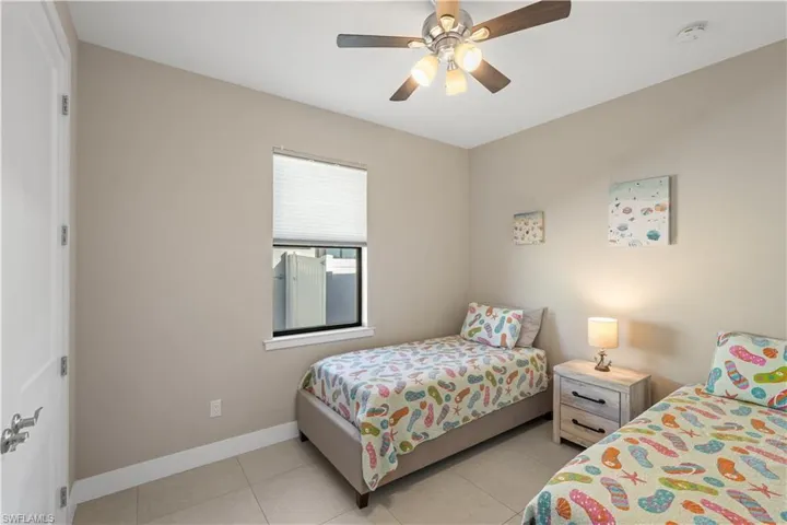 Bedroom with ceiling fan and light tile patterned floors