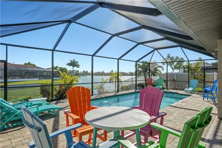 Outdoor pool with a sunroom, a patio area, a lanai, and a water view