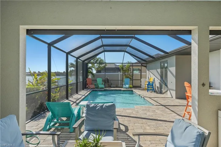 View of pool with a sunroom, patio surround, and glass enclosure