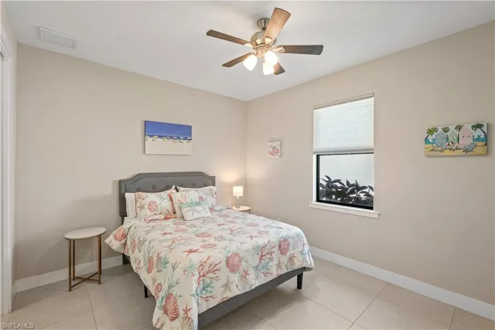 Bedroom with a ceiling fan, light tile patterned floors, and a closet