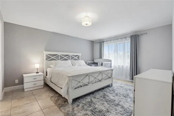 Bedroom with light tile patterned floors and baseboards