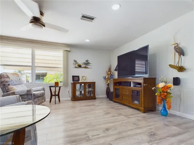Living room with light wood-type flooring and ceiling fan