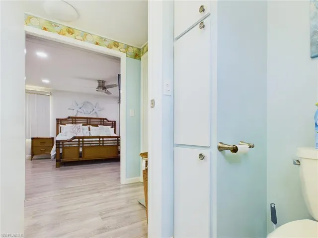 Bathroom with ceiling fan, hardwood / wood-style flooring, and toilet
