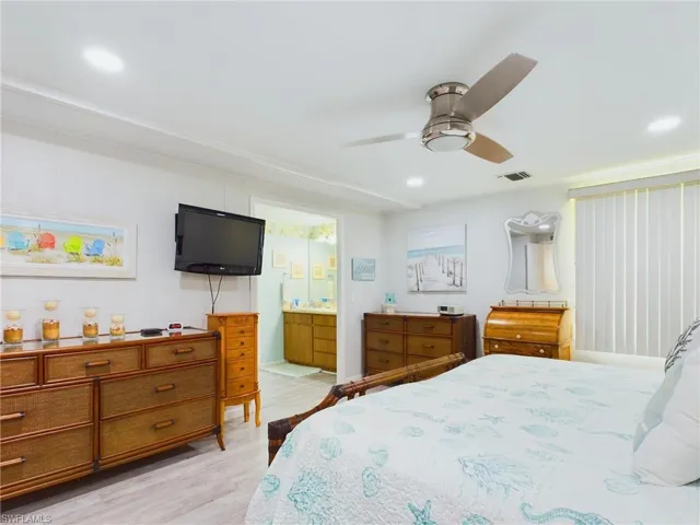 Bedroom featuring ceiling fan, ensuite bathroom, and light hardwood / wood-style floors