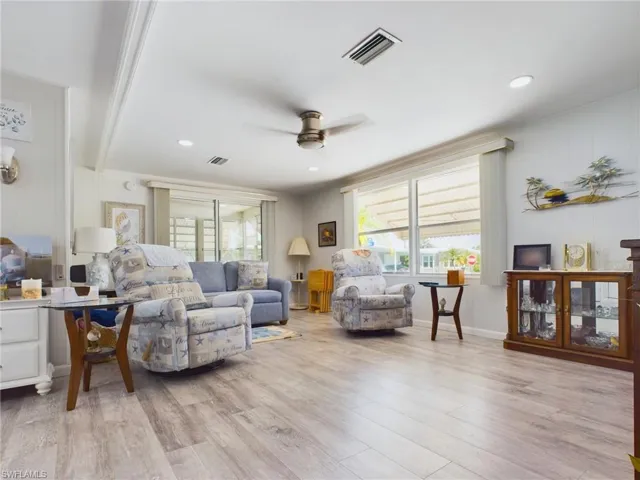 Living room with ceiling fan and light wood-type flooring