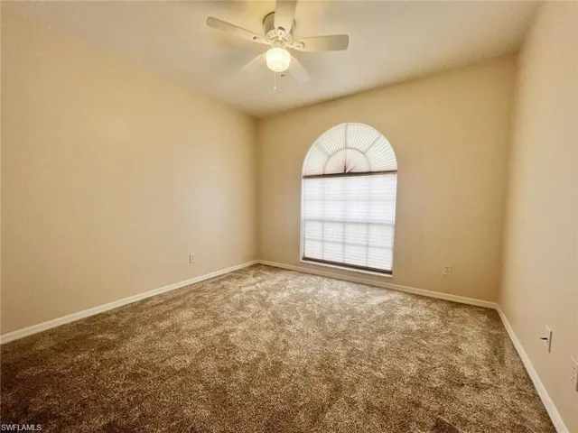 Carpeted spare room with ceiling fan