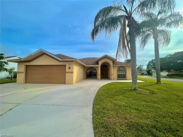 View of front of home with a garage and a front lawn