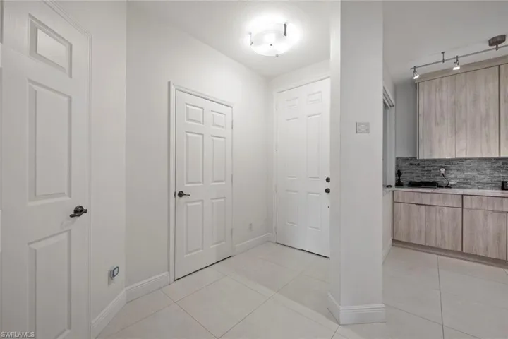 Tiled foyer entrance featuring track lighting