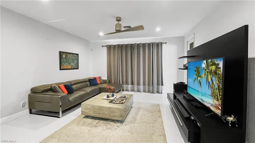 Tiled living room featuring ceiling fan