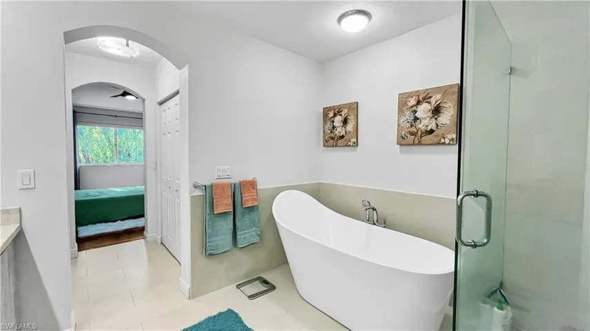 Bathroom featuring tile patterned flooring and shower with separate bathtub